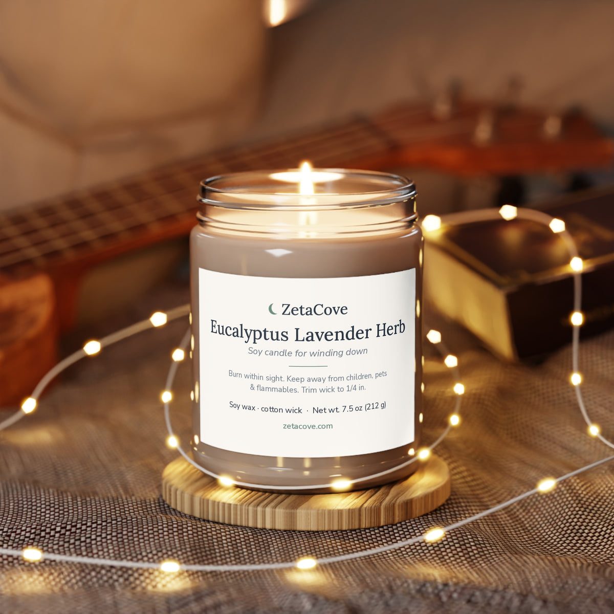 Lit Eucalyptus Lavender Herb candle on a wooden coaster with soft string lights