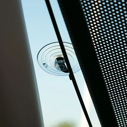 Close-up of the dark mesh and a suction cup on the glass