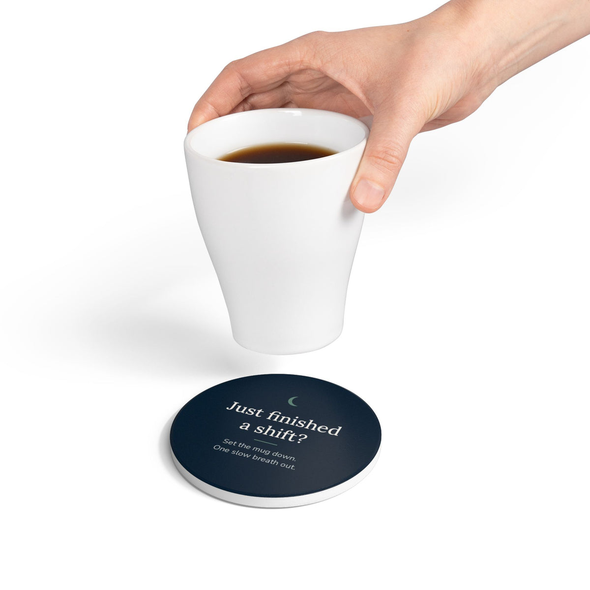 Hand setting a mug down on the round Cove coaster